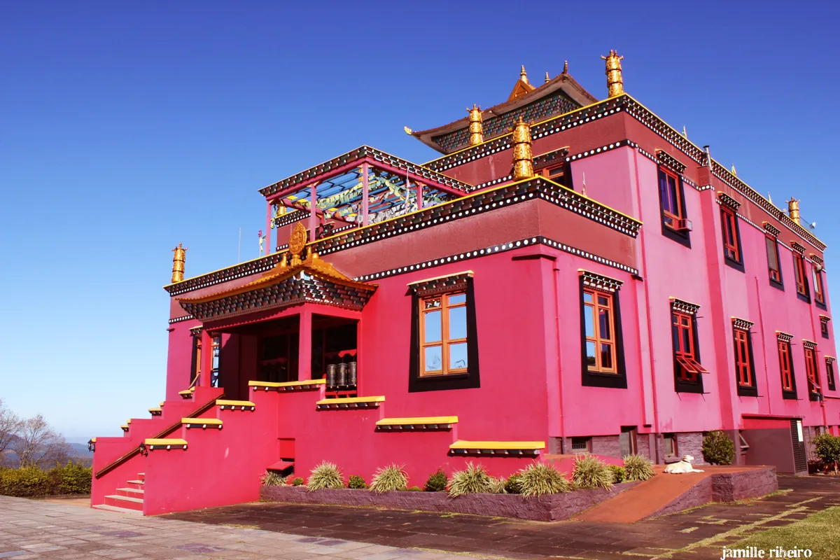 O templo tibetano rosa e dourado do Khadro Ling, em Três Coroas, sob céu azul